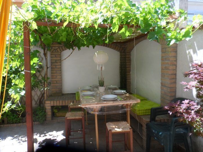 Giardino con pergola di vite e tavolo all'aperto